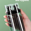 A hand holds two clear glass spray bottles filled with liquid, labeled as safe and hygienic PET material.