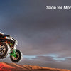 A red and black off-road buggy is shown driving on a dirt track under a dramatic sky.