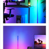 An LED RGB corner floor lamp illuminates a room with vibrant ambient lighting and features a monitor setup.