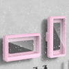 Pink universal waterproof shower phone case with anti-fog screen mounted on a gray wall.