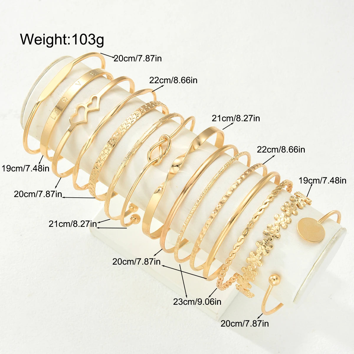 A set of gold-toned bracelets with various sizes and designs, including heart and flower motifs.