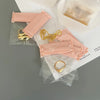 A collection of pink self-sealing storage bags containing various gold jewelry items like rings and necklaces.