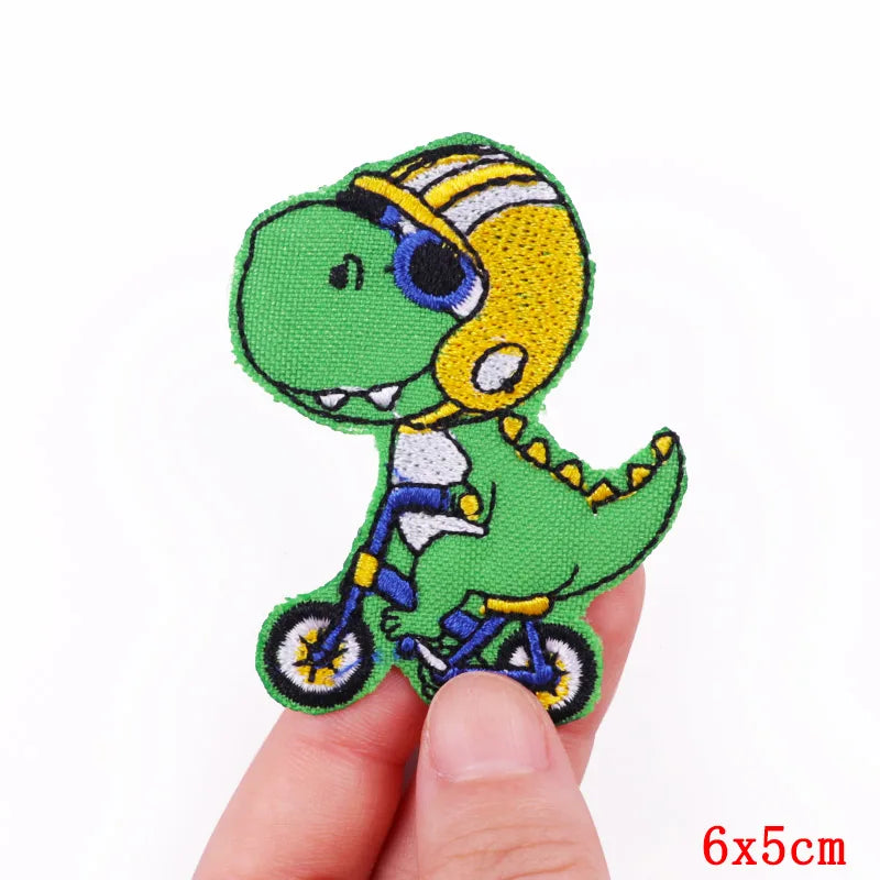 A green cartoon cat embroidery patch featuring a yellow helmet and bicycle details.