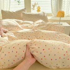 A beige duvet cover set with a cute dog print pattern and matching pillowcases is displayed on a bed.
