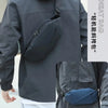 A dark gray waterproof jacket with a black waist pack worn by a person.