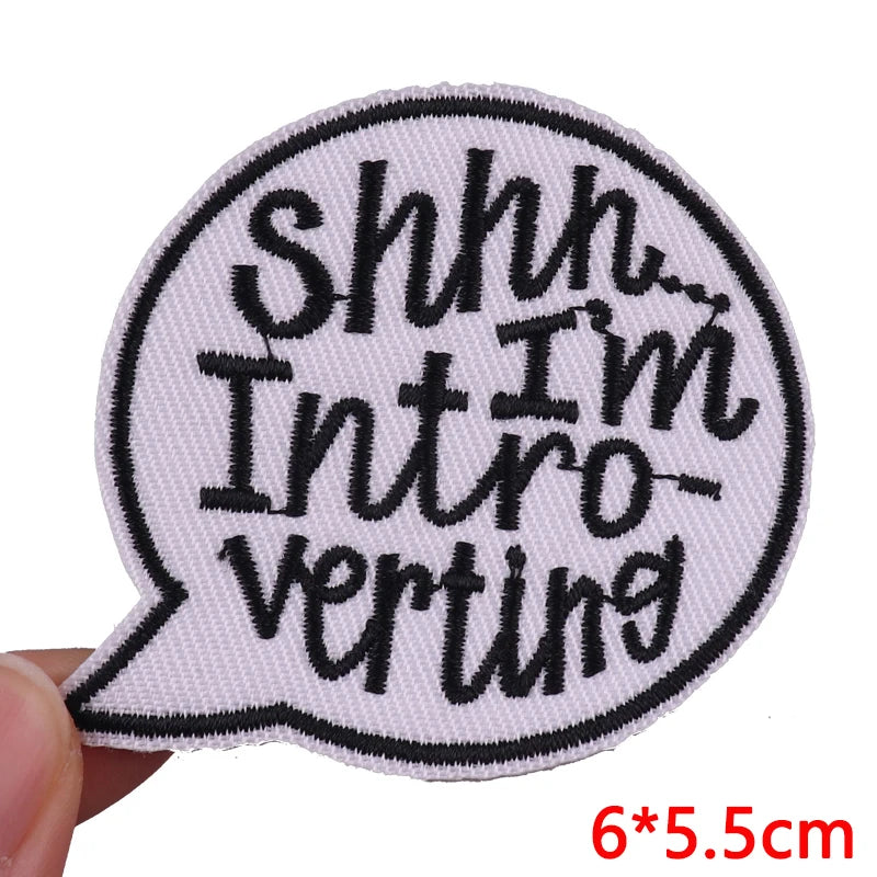 A black and white embroidered iron-on patch shaped like a speech bubble with the text Shhh I'm Introverting