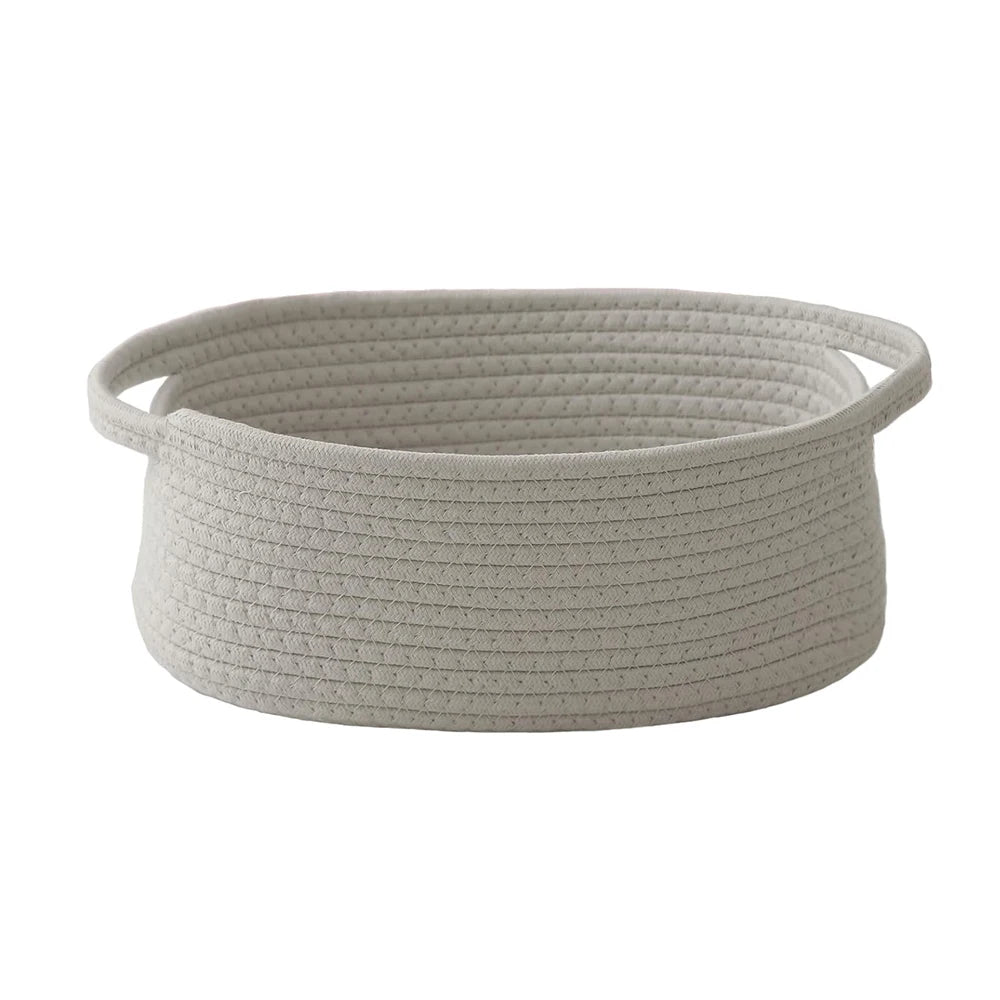 A light gray handwoven rope storage basket with handles.