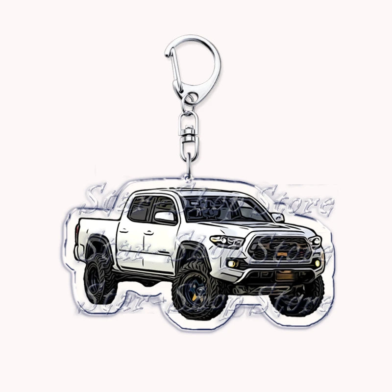 Silver metal key ring attached to a die-cast model of a white off-road truck.