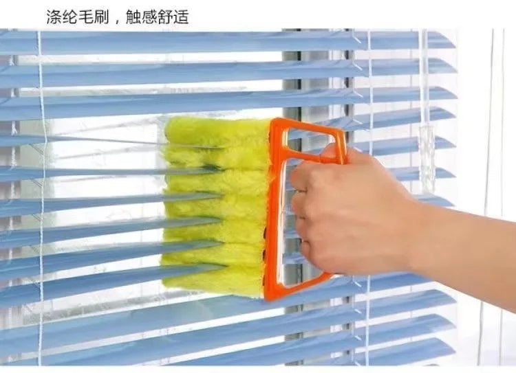 An orange dusting brush is shown cleaning the slats of a blue blind.