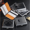 A collection of classic stainless steel cigarette cases with embossed patterns and orange accents arranged on a dark surface.