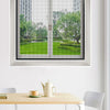 A close-up view of a reusable self-adhesive mosquito window screen installed in a white window frame.