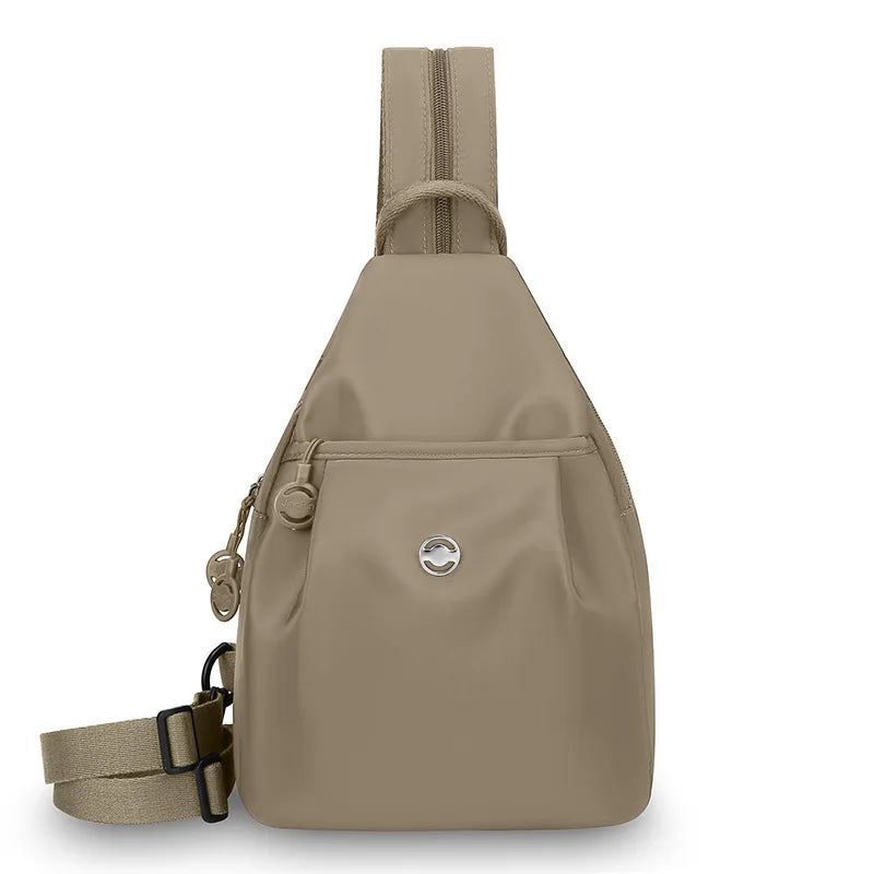 A beige women's lightweight mini backpack with a chest strap visible from the front.