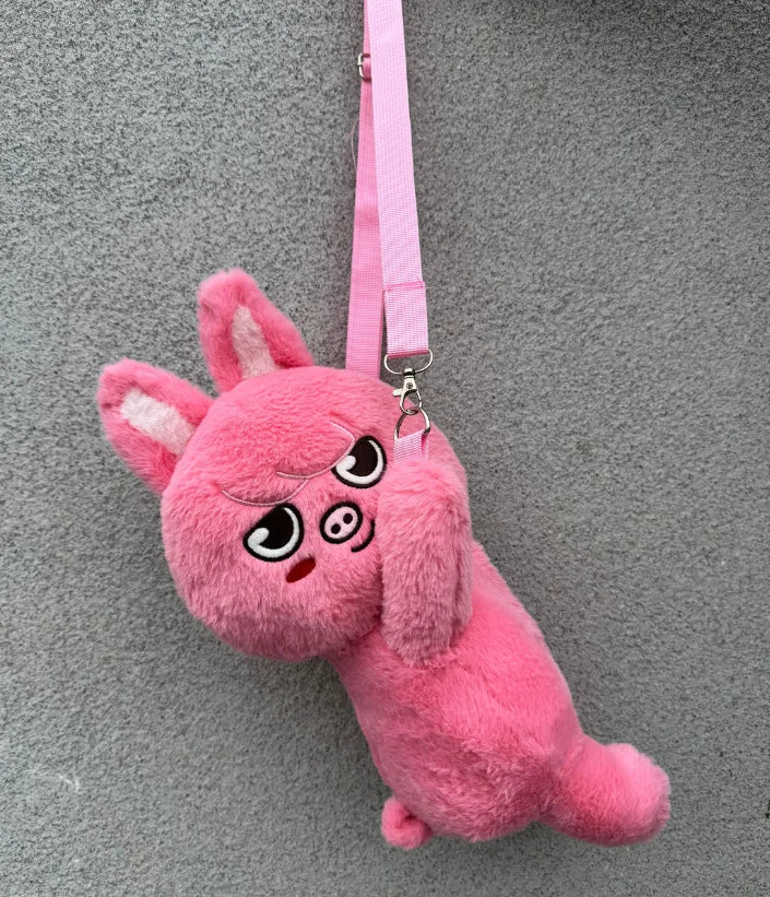 A pink, fluffy plush toy resembling a rabbit character hanging by a pink strap.