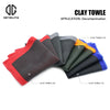 A collection of clay towels in various colors including red, gray, orange, and blue, used for paint decontamination.