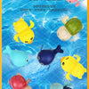 A set of colorful cartoon bath toys including turtles, ducks, and whales floating in blue water.