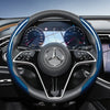 Close-up view of a black steering wheel with blue carbon fiber texture accents inside a Mercedes-Benz vehicle
