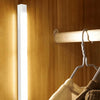 A vertical white LED night light is mounted on a wooden wall, illuminating the area.