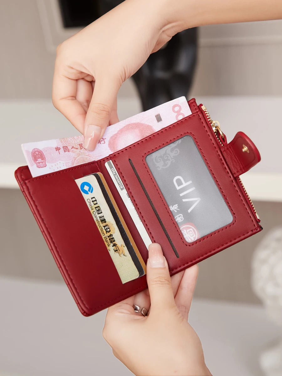 A hand is opening a maroon crocodile-embossed PU leather bifold wallet displaying credit cards and an ID.