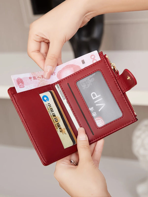 A hand is opening a maroon crocodile-embossed PU leather bifold wallet displaying credit cards and an ID.