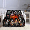 A black and orange printed flannel throw blanket featuring images of the Kiss band members.