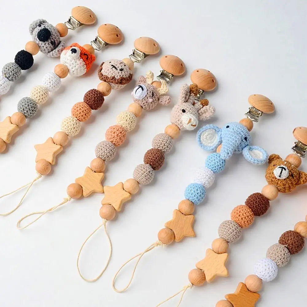 A collection of wooden pacifier clips featuring various colors and textures of crochet beads on a string.