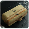 A beige portable storage bag for camping tableware with a brown zipper and strap, resting on a dark surface.
