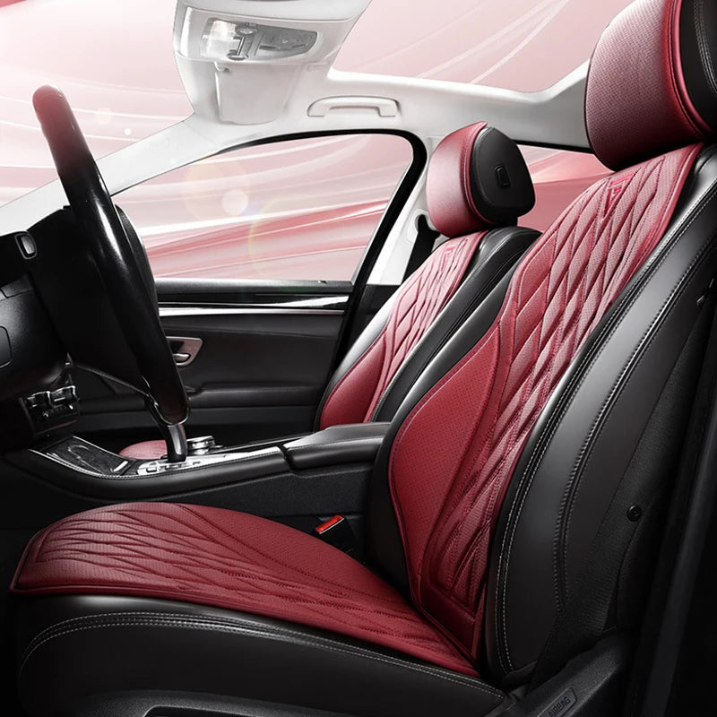 Interior view of a car seat with red quilted leather seat covers and a black steering wheel.