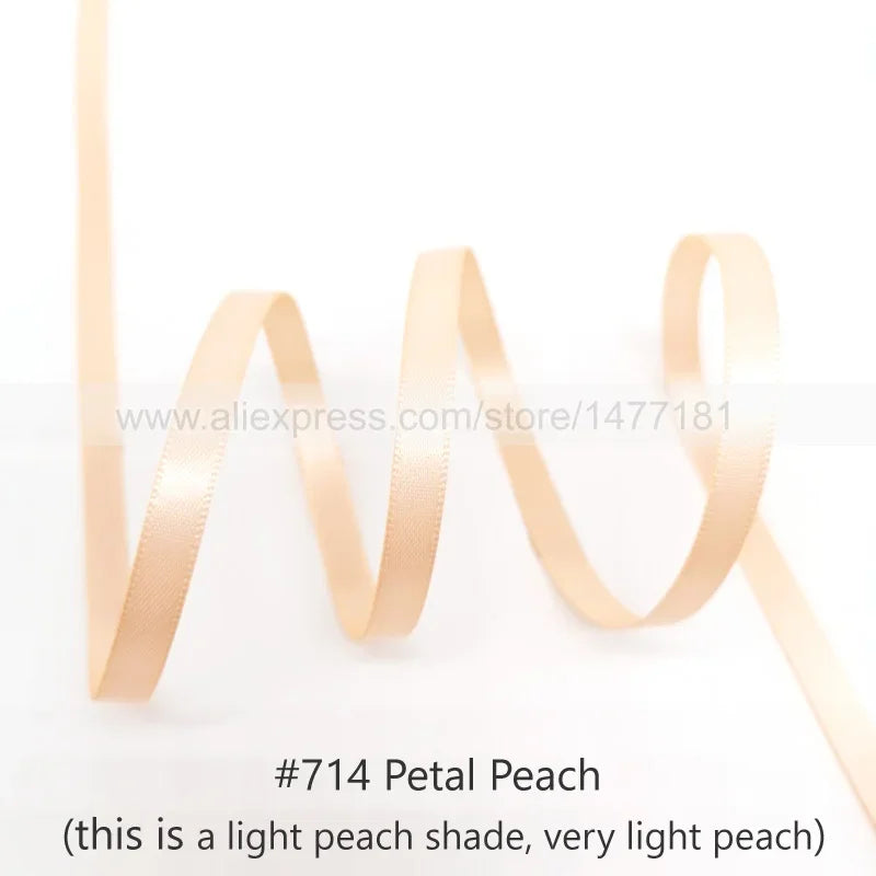A roll of peach-colored satin ribbon used for crafting or decoration.