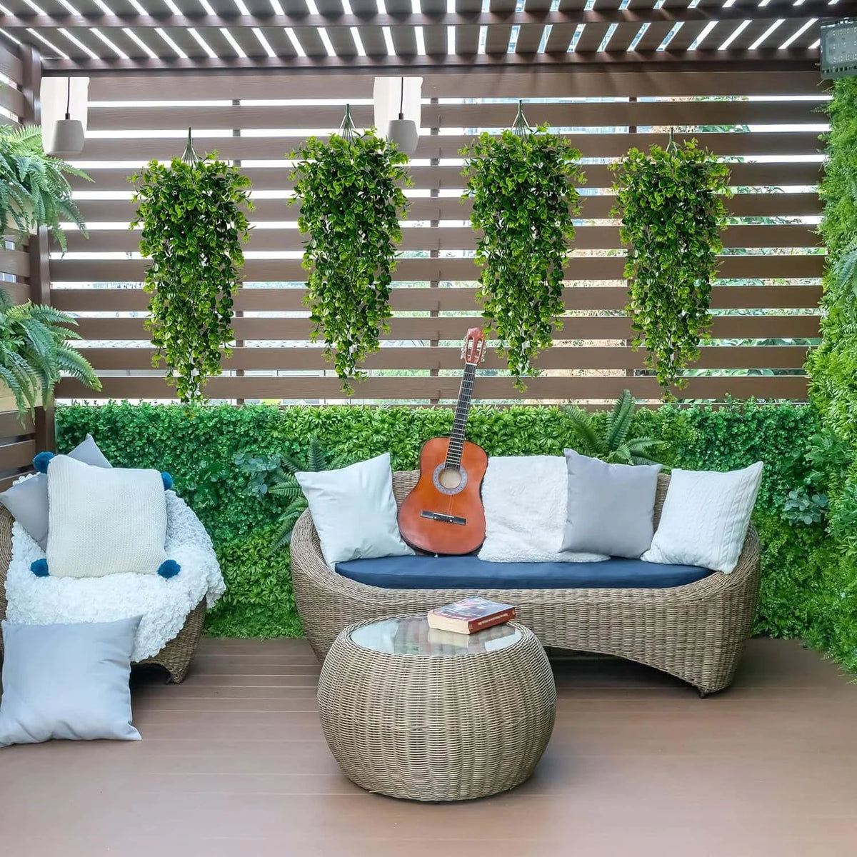 Artificial green hanging vine greenery decorating an outdoor patio area with a wooden fence background