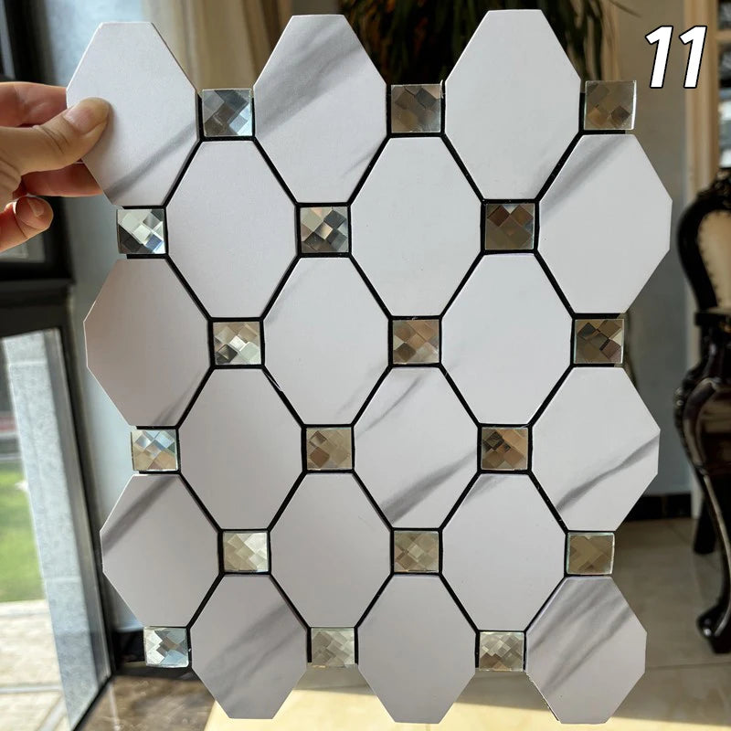 A hand holds a white hexagonal mosaic tile pattern, showing various shades of silver and gold tiles.
