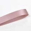 A roll of double face satin ribbon in a dusty rose color.
