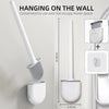 A silicone toilet brush is shown hanging on a wall mount, demonstrating its convenient use and space-saving design.