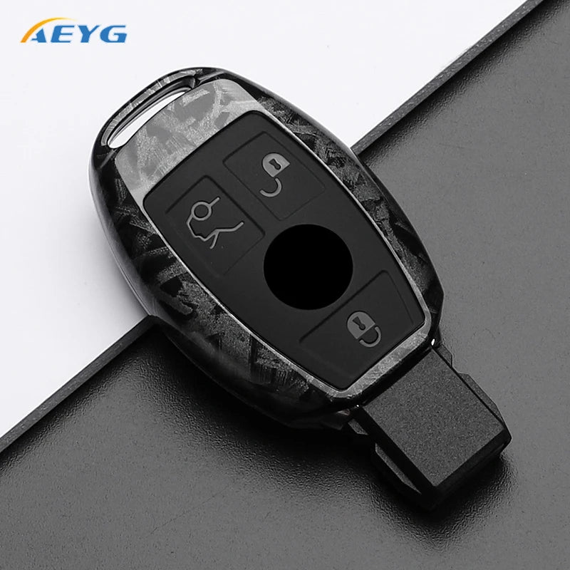 A black slim carbon fiber car key cover with various buttons and a cutout for a key.
