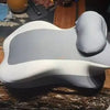 A light gray multi-positional memory foam body pillow with a removable cover resting on a wooden surface.