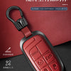 A red leather and metal car key case with a black lanyard attached, featuring a panic button design.