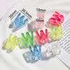 A collection of clear acrylic alphabet beads in various colors and sizes displayed on a white plate.