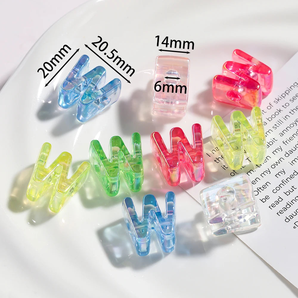 A collection of clear acrylic alphabet beads in various colors and sizes displayed on a white plate.