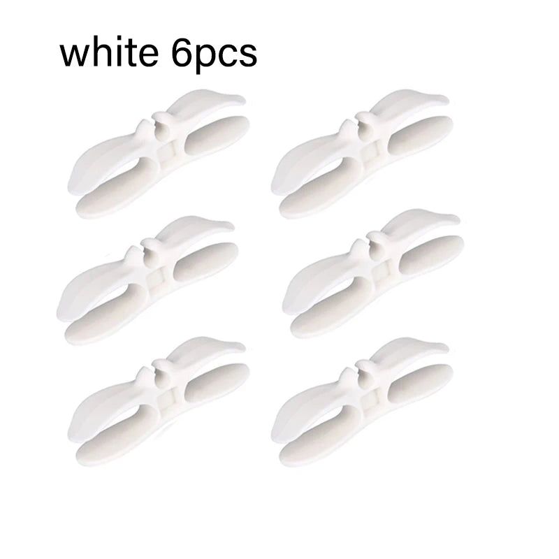 Six white cord organizers or wire winders for tidy cable management.