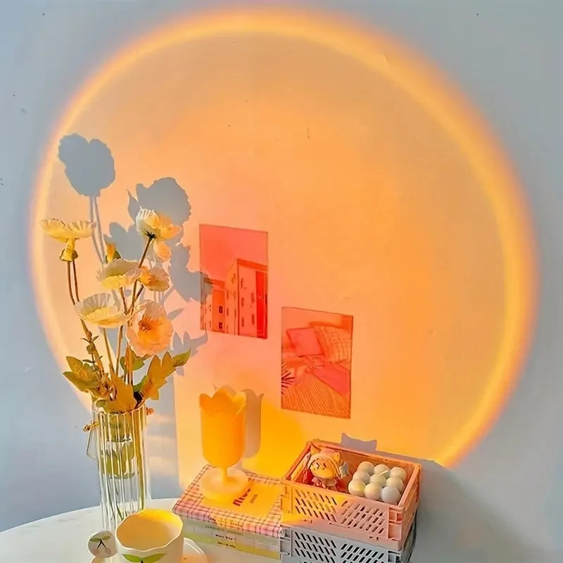 Una lámpara de proyección de atardecer ajustable proyecta un brillo naranja cálido sobre una pared, iluminando diversas pieza