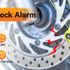 Yellow disc brake lock alarm device attached to a motorcycle wheel, highlighting anti-theft features.