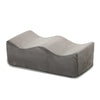 A gray ergonomic memory foam leg support pillow shown from the side.