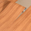 Roll of self-adhesive wood grain wallpaper in a warm reddish-brown tone being applied to a surface.