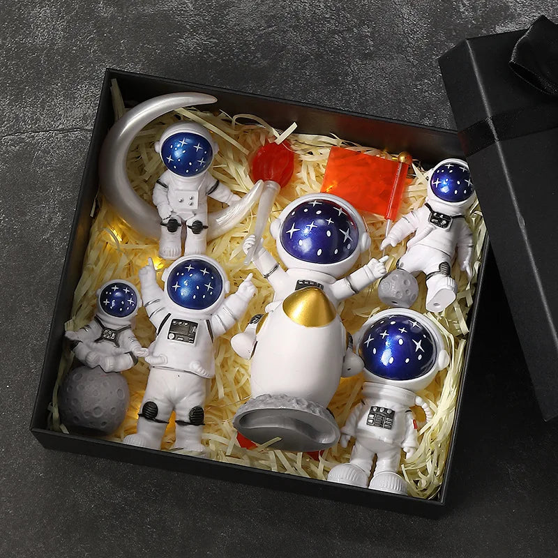 A set of handcrafted astronaut figurine resin spacemen desk decor displayed in a black box.