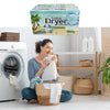 A woman is sitting in front of a washing machine with a box of Tumble Dryer Sheets visible.