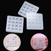 A collection of clear epoxy resin molds shaped like butterflies in various sizes and colors.
