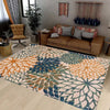 A rectangular outdoor area rug featuring a tropical botanical pattern in shades of orange, teal, and blue on a light floor.