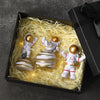 A set of handcrafted astronaut figurine resin spacemen desk decor displayed in a black box surrounded by straw-like material.