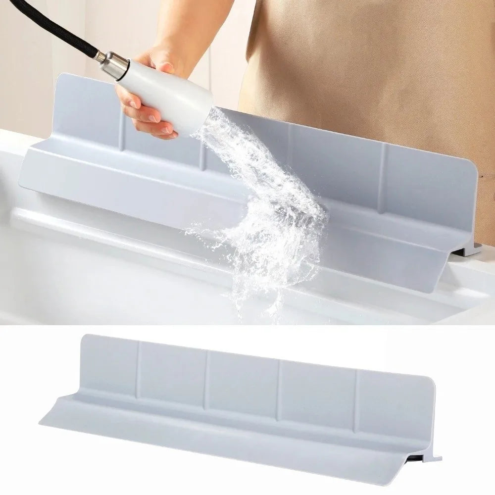 A hand is using a flexible silicone sink splash guard with a strong suction cup to spray water into a sink.