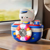 A white cat-shaped camera-shaped automatic bubble machine with lights and music sitting on a wooden surface.