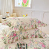 A set of two floral cotton pillowcases featuring pink and green roses on a white background.
